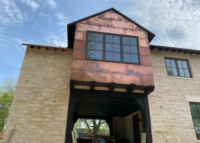 Copper metal panel facade on a stone building for Skylight Installation in Dubuque