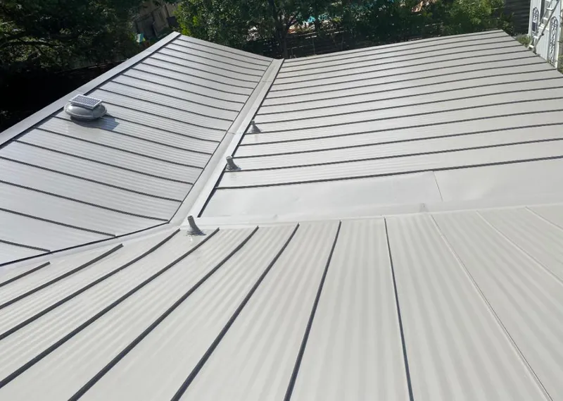 Solar attic fan installed on a metal roof for Roof Ventilation in Dubuque