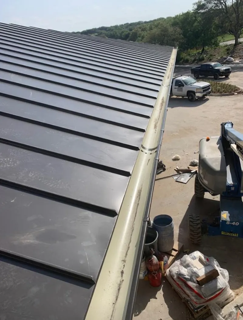 Standing seam panel and gutter detail on a metal roofing jobsite in Dubuque